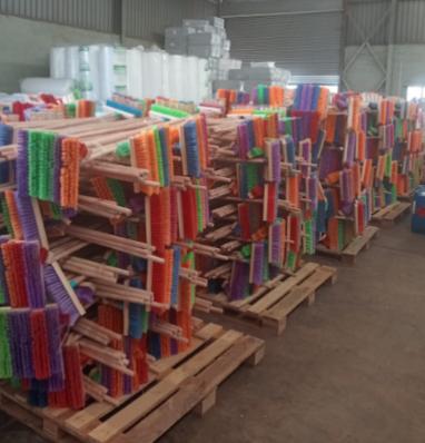 Pallets stacked with colourful brooms in the DV B-CO warehouse